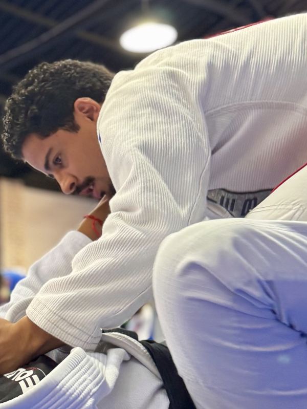 Victor de quimono branco durante um treino de jiu-jítsu
