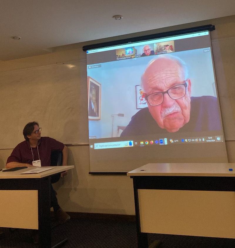 Stanley Fish falando por videoconferência, projetado num telão de auditório